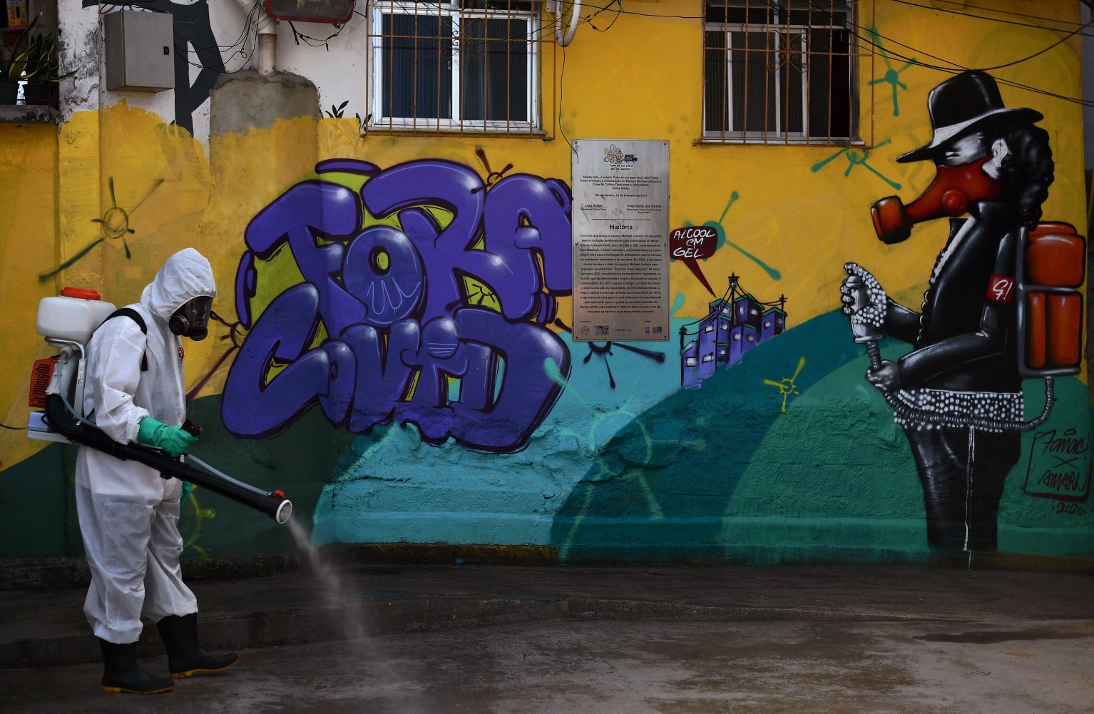 A volunteer disinfects an area inside Santa Marta Favela in Brazil