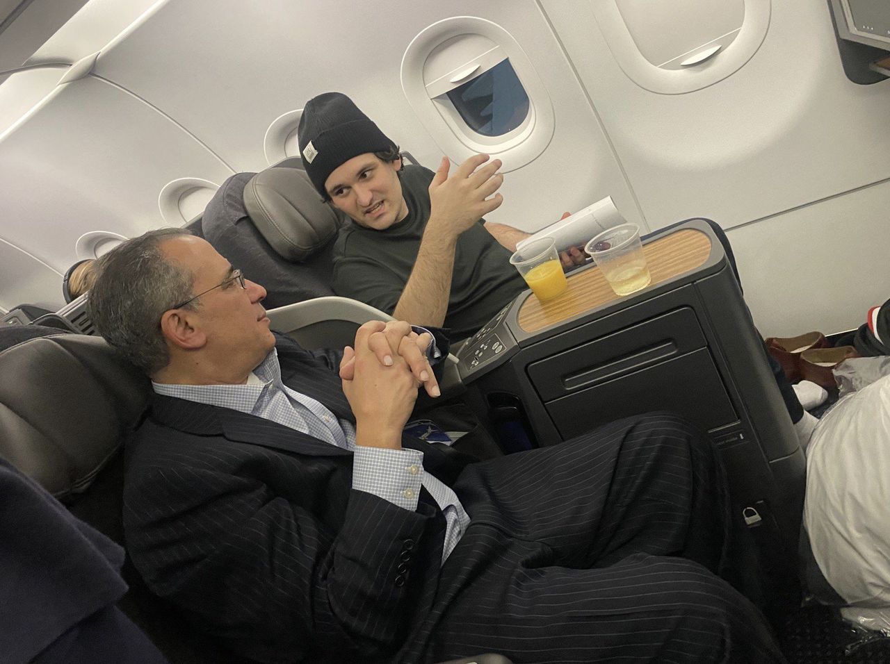 'Crime' DOES pay! FTX 'fraudster' Sam Bankman-Fried relaxes at JFK lounge and on business class AA seat 'as he flies home to California after being freed on $250m bail over $1.8bn crypto scam'